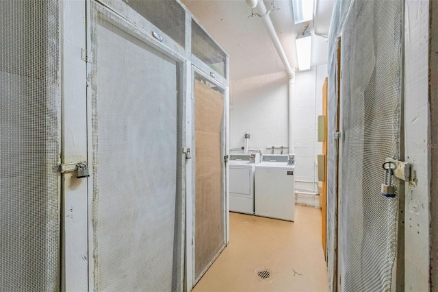 bathroom featuring washing machine and clothes dryer and concrete flooring