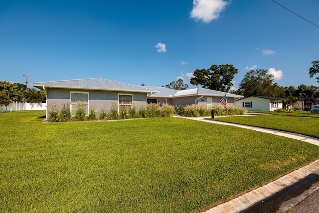 ranch-style house featuring a front yard, fence, and brick siding