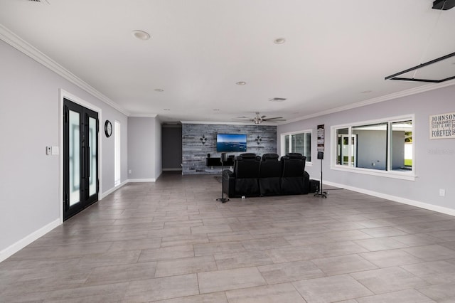 living area with ornamental molding, an accent wall, and baseboards