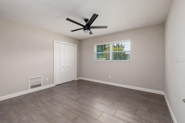 unfurnished room with baseboards, visible vents, and a ceiling fan