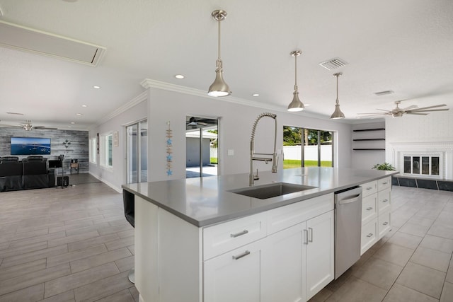 kitchen with stainless steel dishwasher, an accent wall, open floor plan, and a sink