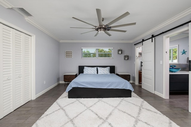 bedroom featuring a closet, visible vents, crown molding, and a barn door