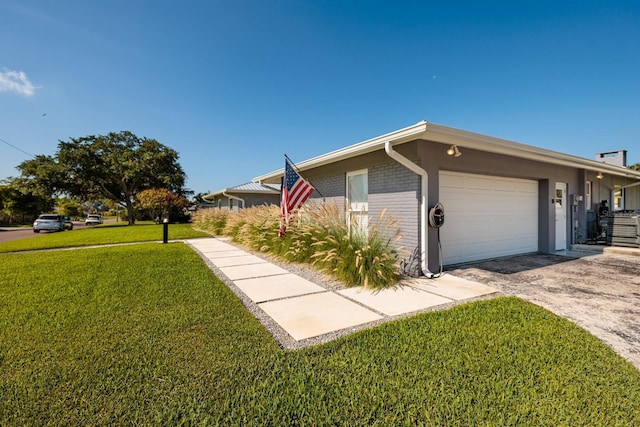 view of front of house featuring brick siding, an attached garage, and a front lawn