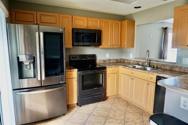 kitchen featuring black appliances, light brown cabinets, light tile patterned floors, and sink