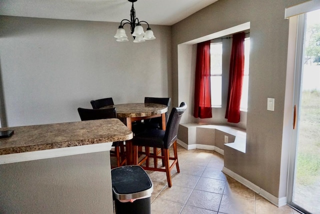 dining room featuring light tile patterned floors, a healthy amount of sunlight, and a notable chandelier