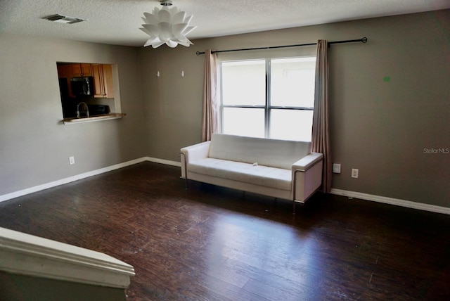 unfurnished room with a textured ceiling and dark hardwood / wood-style floors