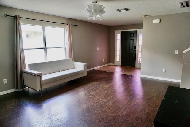 foyer featuring a textured ceiling and dark wood-type flooring