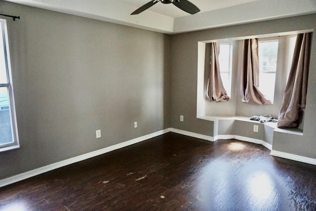 unfurnished room with ceiling fan and dark wood-type flooring