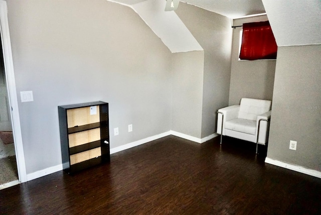 bonus room with a textured ceiling, dark wood-type flooring, and vaulted ceiling