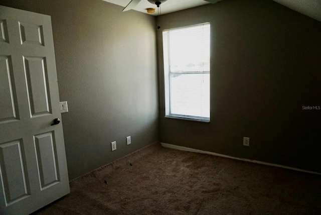 carpeted empty room with vaulted ceiling and ceiling fan