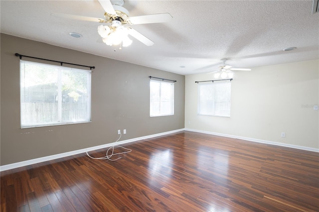 spare room featuring a textured ceiling, dark hardwood / wood-style flooring, and a wealth of natural light