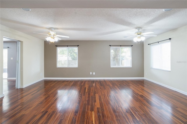 spare room with a textured ceiling, ceiling fan, and dark hardwood / wood-style floors