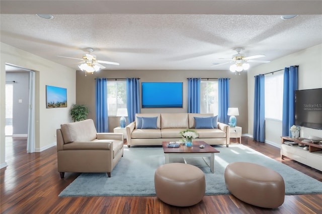 living room with dark hardwood / wood-style floors, ceiling fan, and a textured ceiling