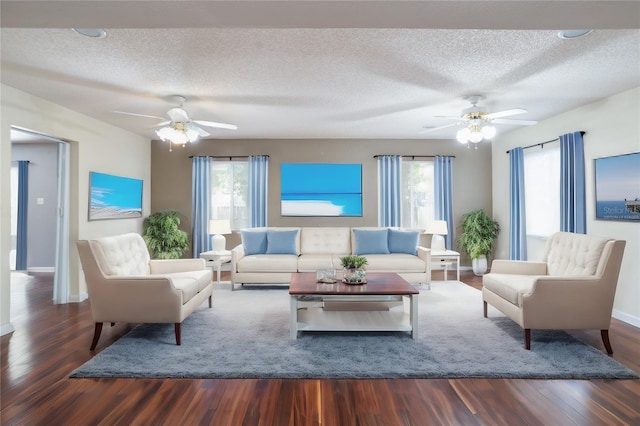 living room with dark hardwood / wood-style floors, a healthy amount of sunlight, and a textured ceiling