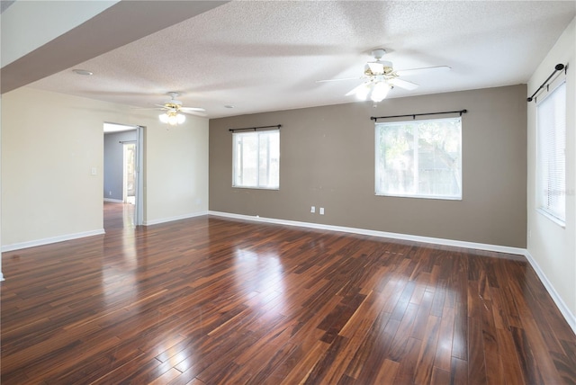 unfurnished room featuring a barn door, dark hardwood / wood-style flooring, and a textured ceiling