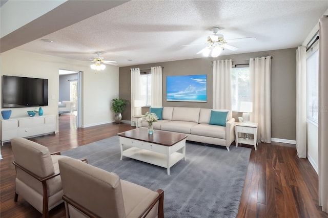 living room with ceiling fan, dark hardwood / wood-style flooring, and a textured ceiling