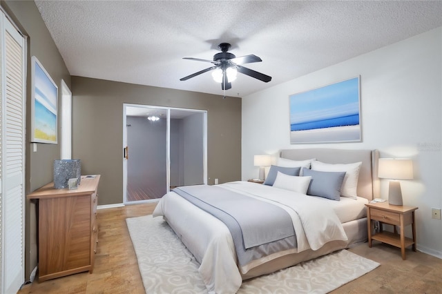 bedroom with ceiling fan and a textured ceiling