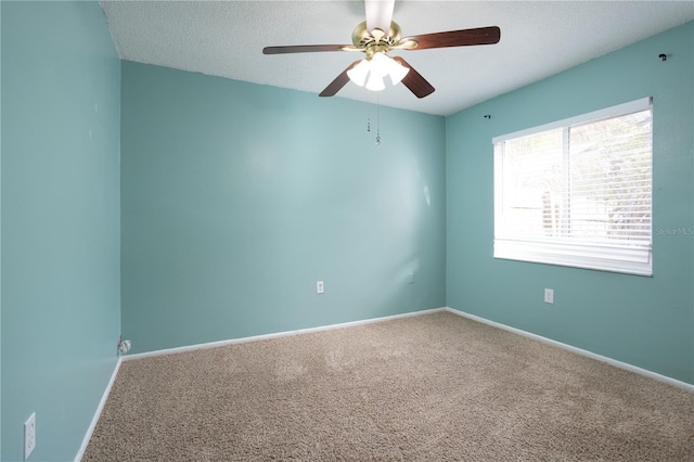 empty room with ceiling fan, carpet floors, and a textured ceiling