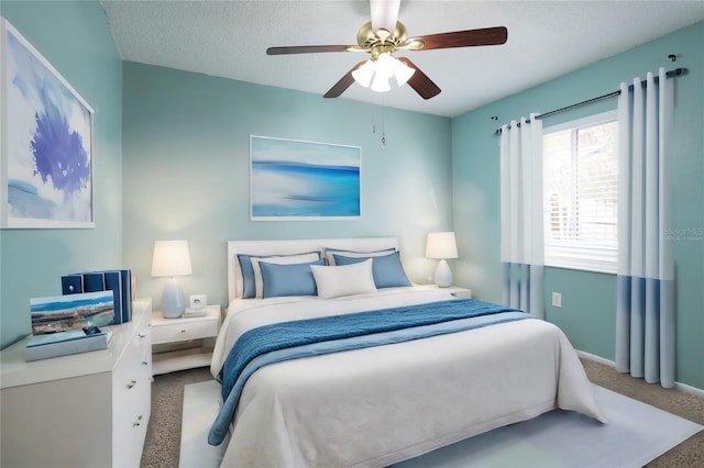 carpeted bedroom with ceiling fan and a textured ceiling