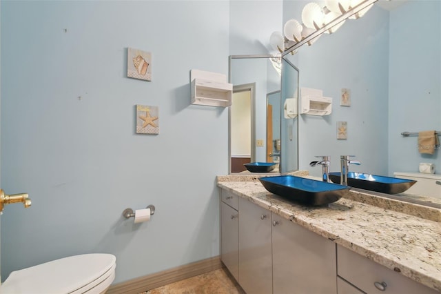 bathroom with tile flooring, toilet, and vanity