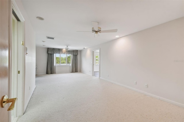 carpeted spare room featuring ceiling fan