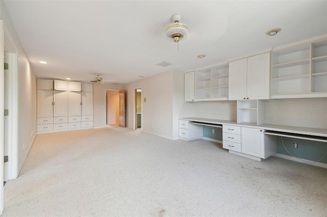 unfurnished office featuring ceiling fan and built in desk