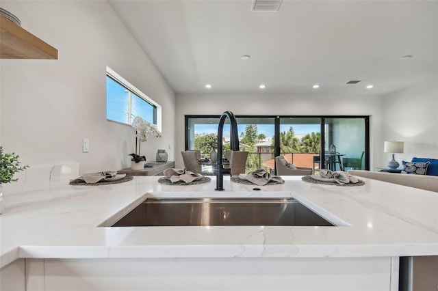 kitchen with light stone counters and sink