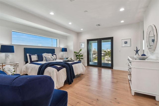 bedroom featuring light hardwood / wood-style floors, french doors, access to outside, and multiple windows