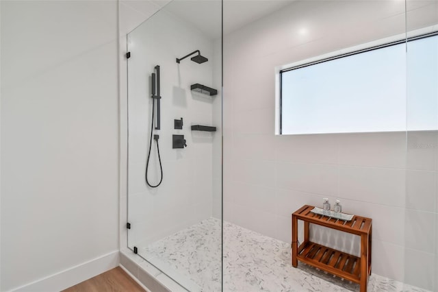 bathroom with wood-type flooring and tiled shower