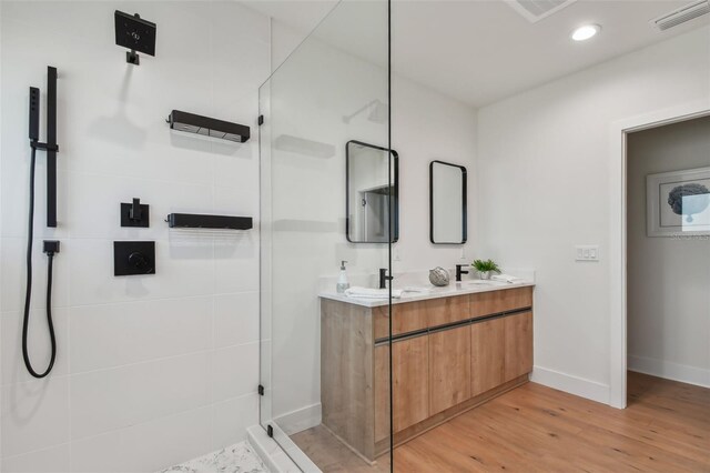 bathroom with hardwood / wood-style floors, vanity, and walk in shower