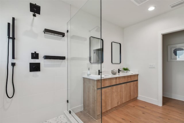 bathroom featuring vanity, hardwood / wood-style floors, and a tile shower