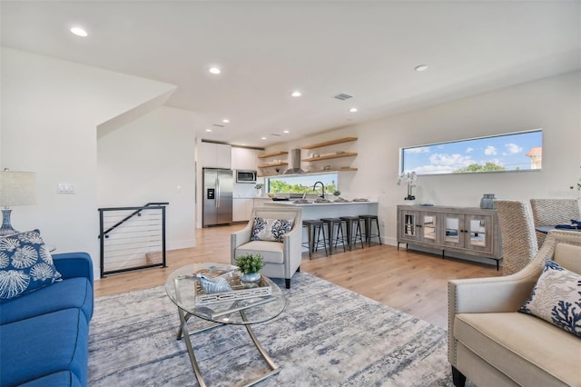 living room with sink and light hardwood / wood-style floors