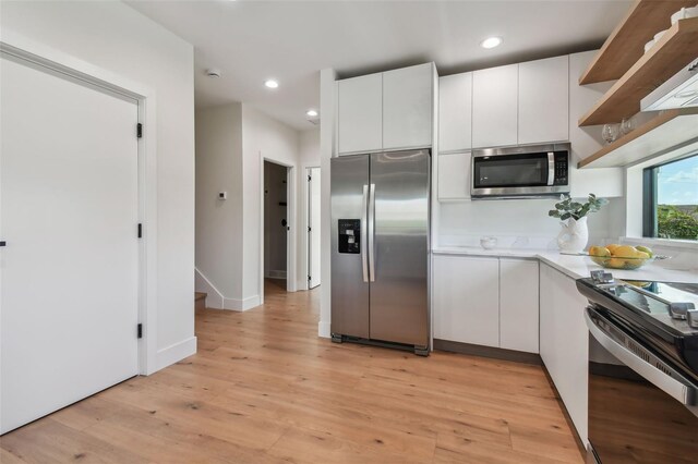 kitchen featuring white cabinetry, stainless steel appliances, and light hardwood / wood-style floors