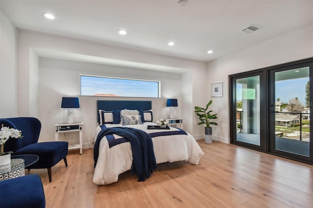 bedroom with access to exterior and light hardwood / wood-style flooring