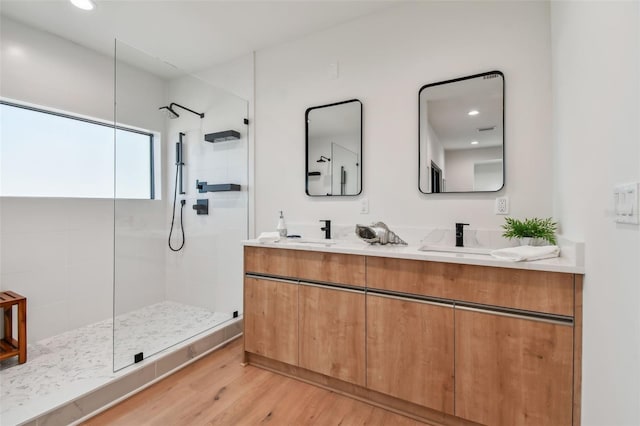 bathroom featuring tiled shower, vanity, and hardwood / wood-style flooring