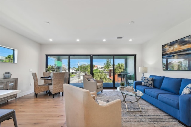 living room with light wood finished floors, visible vents, recessed lighting, and baseboards