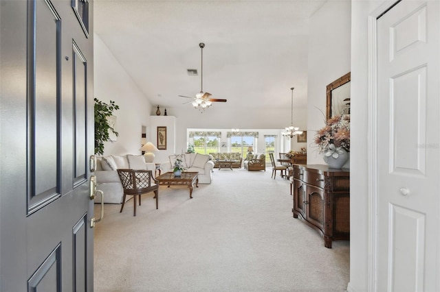 interior space featuring high vaulted ceiling, light colored carpet, and ceiling fan with notable chandelier