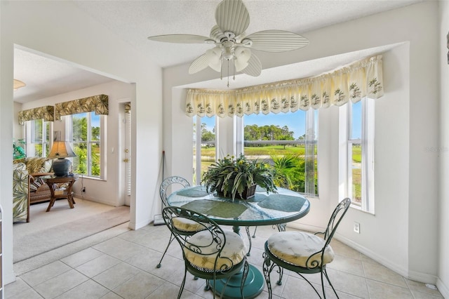 tiled dining area featuring a textured ceiling and ceiling fan