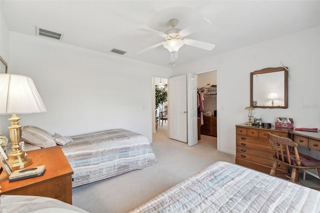 carpeted bedroom featuring ceiling fan, a walk in closet, and a closet