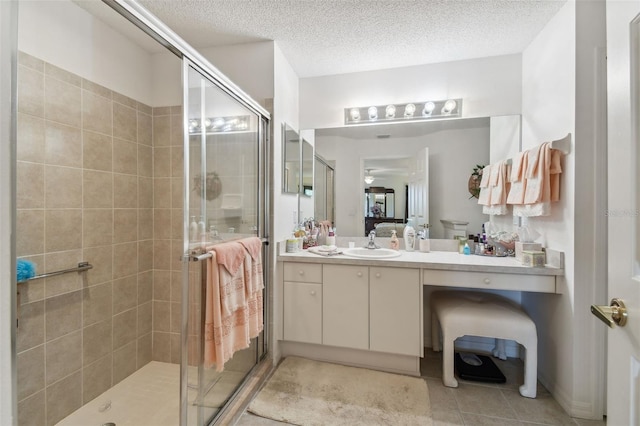 bathroom with vanity, a shower with door, and a textured ceiling