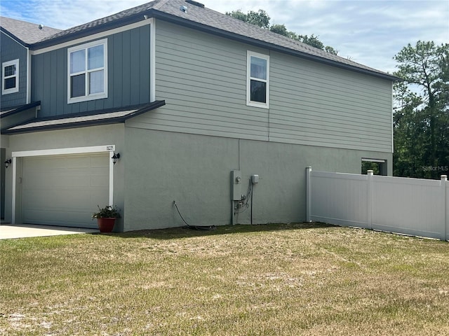 view of home's exterior with a garage and a lawn