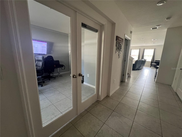 corridor featuring light tile patterned floors and french doors