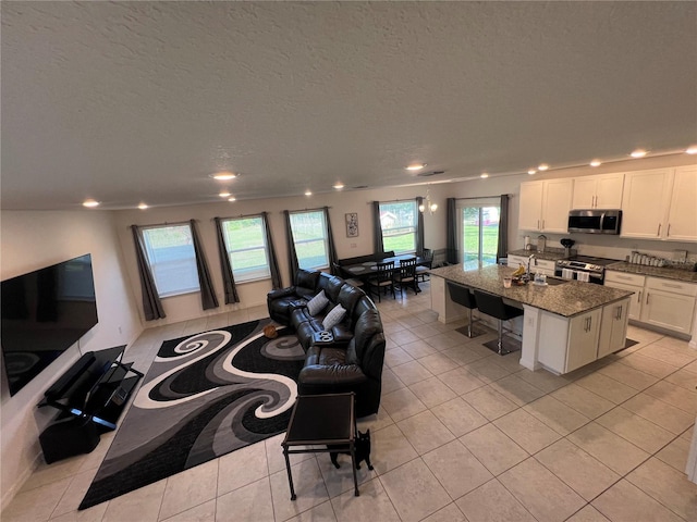 tiled living room with a textured ceiling and sink