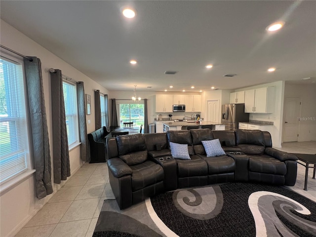 tiled living room with a notable chandelier