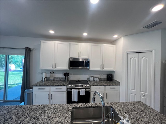 kitchen with white cabinetry, sink, appliances with stainless steel finishes, and dark stone counters