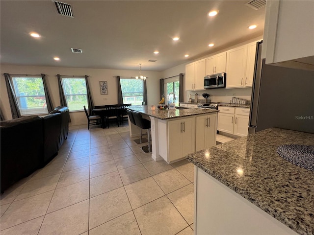 kitchen featuring white cabinets, sink, an island with sink, and stainless steel appliances