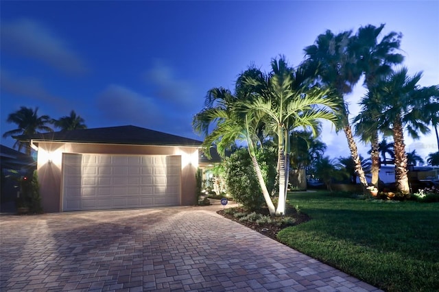 view of front of home featuring a garage and a lawn