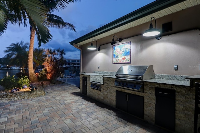 patio terrace at dusk featuring area for grilling