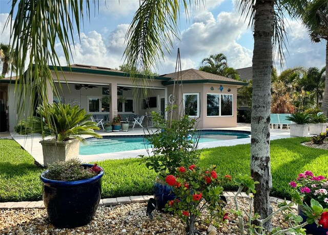 back of property featuring ceiling fan, a yard, and a patio area