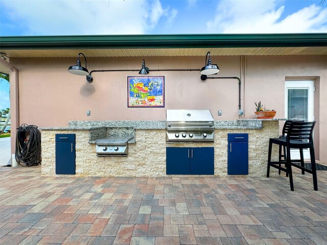 view of patio featuring an outdoor kitchen, grilling area, and a bar